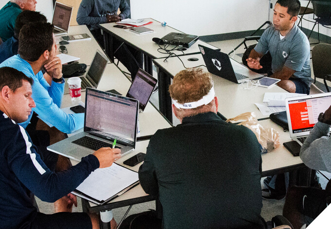 A goups of analysts meeting with an expert from Hudl