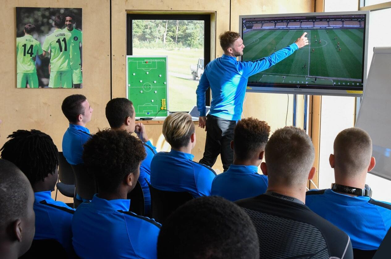 A football team watching and analyzing their game footage
